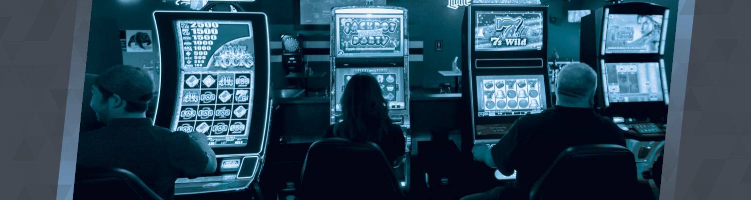 People playing and facing slot machine games at GEM Gaming