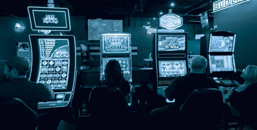 People playing and facing slot machine games at GEM Gaming